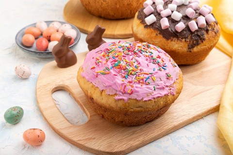 Homemade glazed and decorated easter pies with chocolate eggs and rabbits on a white concrete