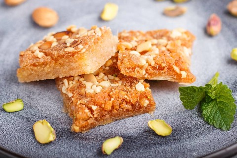 Traditional arabic sweets in gray ceramic plate on a gray concrete background. side view, close up,