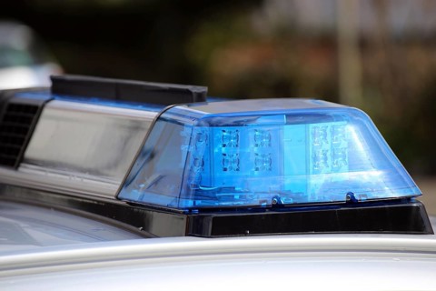 Symbolic image: Close-up of a police car with flashing blue lights