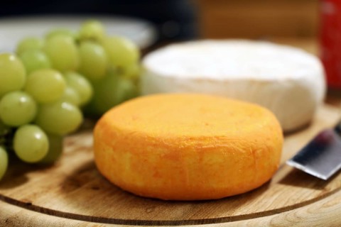 Cheese platter with various types of soft cheese and grapes