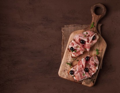 Breakfast, bacon and olives sandwich, on a cutting board, top view, close-up, no people