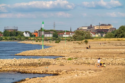 Low water on the Rhine at Duisburg-Homberg, view of Duisburg-Laar, houses on Deichstraße, gasometer
