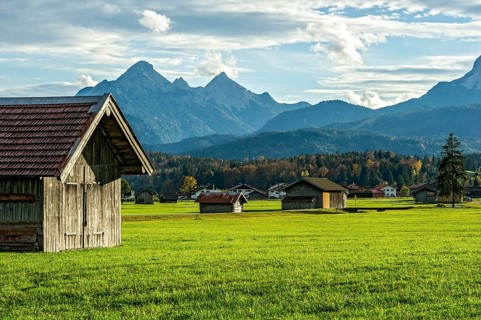Green meadow with hay huts, behind Große, Mittlere and Hintere Arnspitze of the Arnspitzgruppe,