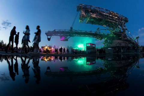 Festival visitors walk under one of the excavators at the Melt Festival in Ferropolis on 13 July