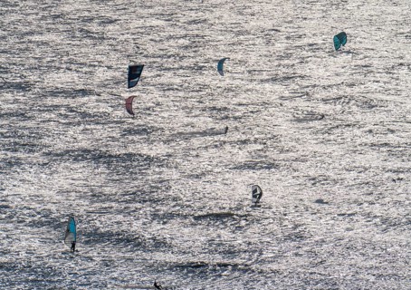 Kitesurfers and windsurfers in strong winds on the beach of Scheveningen, The Hague, Netherlands