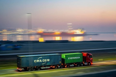 Lorry on the road from Euromax Terminal Rotterdam, ENECO wind farm on the dike around the port of