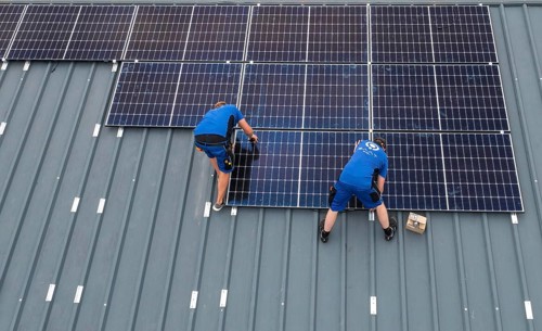 Installation of solar modules on the roof of a barn on a farm, over 240 photovoltaic modules are