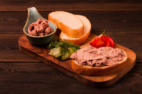 Liver meat pate spread, on white bread, on a wooden background, breakfast, close-up, no people,