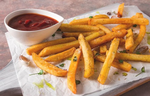Fried French fries, in a paper bag, on an abstract background, no people, rustic