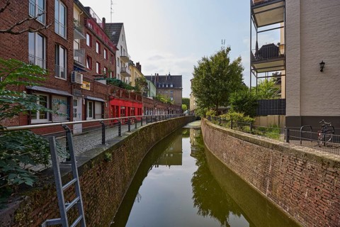 Residential and commercial building on the Nördliche Düssel river in the historic city centre of