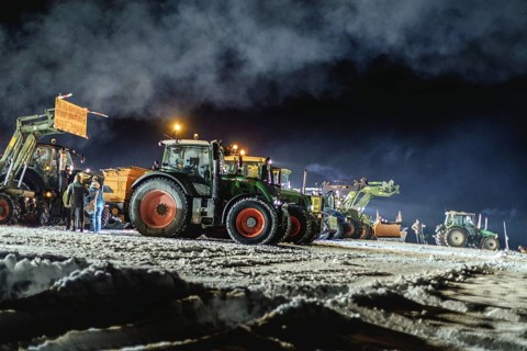 Tractors during a rally as part of the farmers' protests on the snow-covered Kirchbichl,