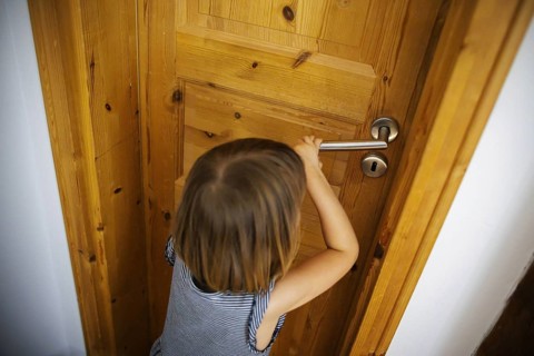Symbolic photo: A small child tries to open a locked door. Berlin, 21.08.2024