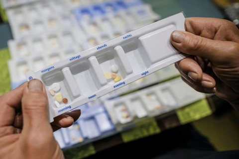 Symbolic photo on the subject of taking medication in old age. Two senior citizens sort various