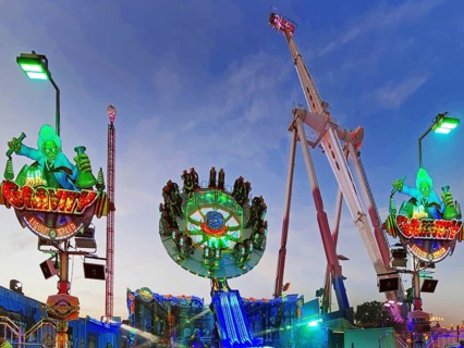 People on the illuminated carousel Mr Gravity in the evening, Cranger Kirmes, Herne, Ruhr area,