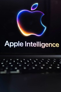 Apple logo in bright neon colours on a Macbook with illuminated keyboard and the text 'Apple
