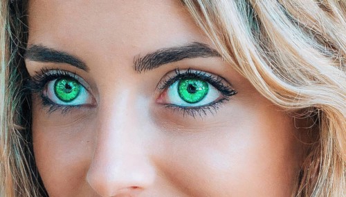 Intense close-up of a female face with green eyes and blonde hair, strong eye make-up, AI