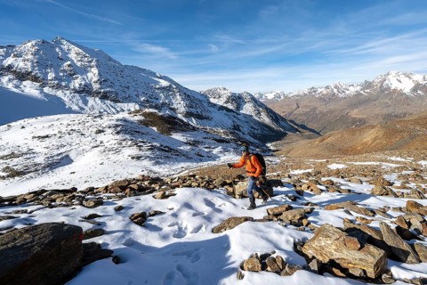 Mountaineer on a hiking trail with snow, descent from Ramoljoch at Spiegelferner, autumnal mountain