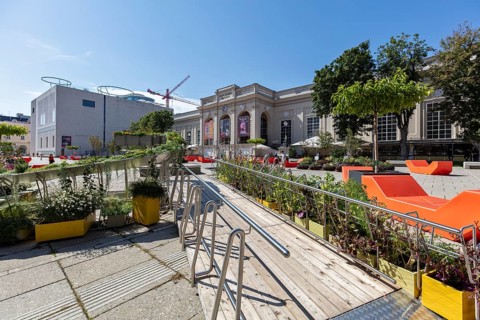 Relaxed atmosphere in an open-air café with modern architecture and lively city life, Vienna