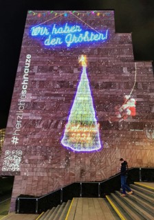 Digital projection of a Christmas tree on the gable wall of the City and State Library on the