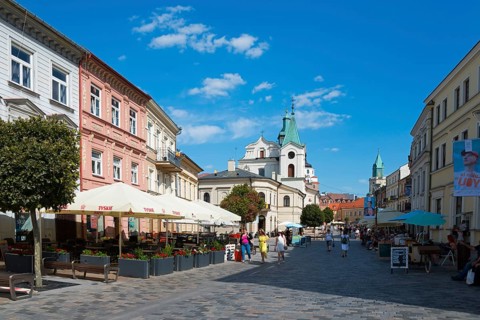 Lively historic street with church, cafés and passers-by under a blue sky, Church of the Holy