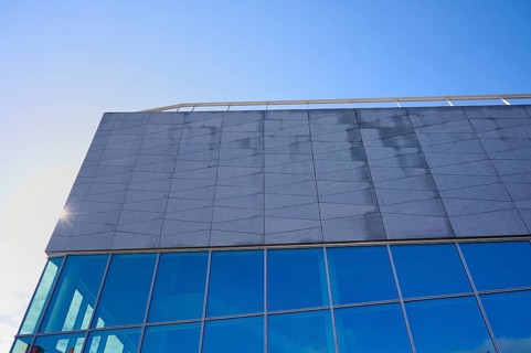 Modern building More og Romsdal Art Centre with glass front and reflecting blue sky, Molde,