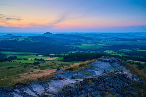Hilly landscape at dusk with colourful sky and meadows in the foreground, Abtsroder Kuppe,