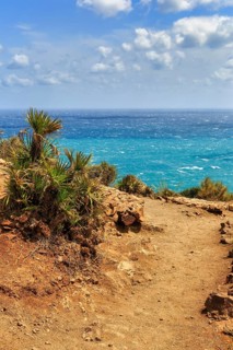 Hiking trail at Mirador de La Amatista with views of turquoise sea, coastline at La Isleta, sunny