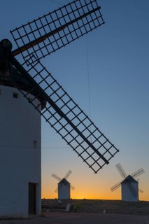 Close-up of a windmill in the foreground with two others on the horizon at sunset, windmills, Campo