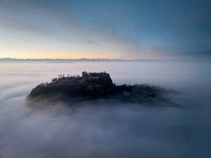 Aerial view of the Hegau volcano Hohentwiel with the upper fortress ruins in front of sunrise,