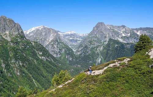 Mountaineer on hiking trail to Aiguillette des Posettes, mountain panorama with summit Mont Bues