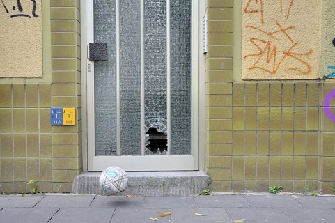 Shattered glass pane on a front door and football, Germany, Europe