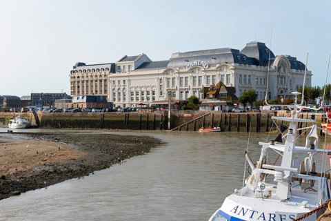 Large historic riverside building with boats in the foreground, Casino Barrière, casino,