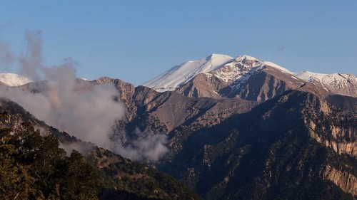 Mountains with snow-covered peaks and some clouds in a calm, natural atmosphere, Omalos Plateau,