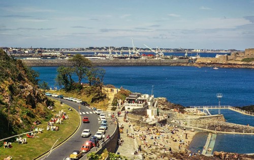 Menschen beim Sonnenbaden an der Küste, St. Peter Port, Guernsey, Kanalinseln, Großbritannien, Juni
