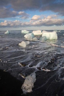 Little icebergs and crushed ice on the black beach at Joekulsarlon glacial lake