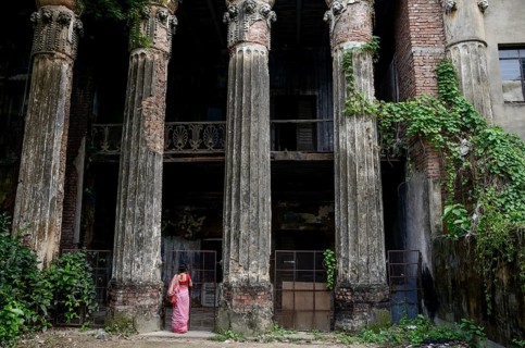 Woman standing below old palace, Kolkata, West Bengal, India, Asia