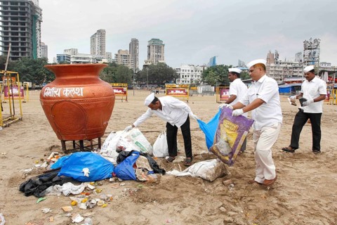 Dabbawalas clean the Chowpatty beach in Mumbai, India on September 16, 2016, and remove