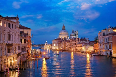 View of Venice Grand Canal with boats and Santa Maria della Salute church in the evening from Ponte