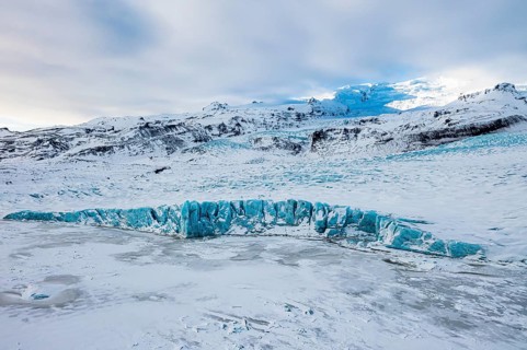 Snow-covered icebergs in the Fjallsarlon glacier lagoon, with the Öraefajökull glacier behind,