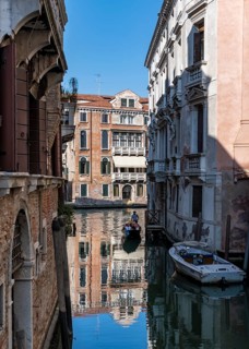 Gondola travelling through a small canal, reflection, Venice, Italy, Europe