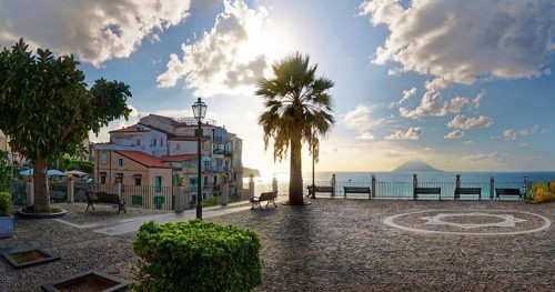 Belvedere Piazza del Cannone town square with the sun at its lowest and the Stromboli volcano in