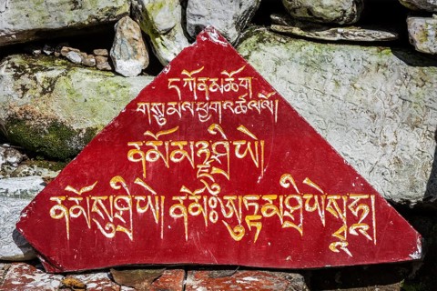 Buddhist prayer mantras on stones in Tibetan Buddhism temple