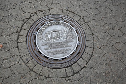 Manhole cover as advertising from the company Dannhäuser GmbH for individual production of motifs,