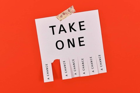 Tear-off stub note with text 'Take a chance' on red background