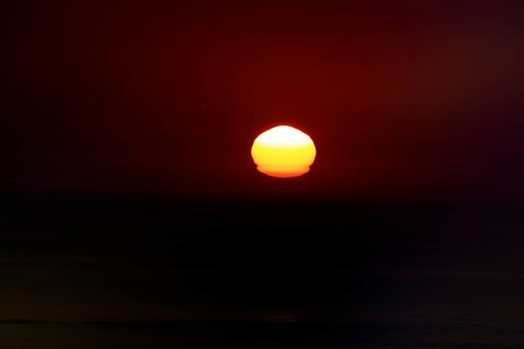 Refraction and reflection at sunset, deformation, unusual deformation in haze, Bassin d'Arcachon,