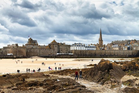 View of the city wall and cathedral from the Fort National, walkers on the beach, Saint-Malo,