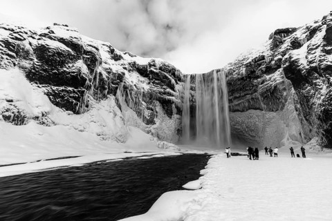 Skogafoss waterfall with icy and snowy rock face, black and white photo, Sudurland, Iceland, Europe