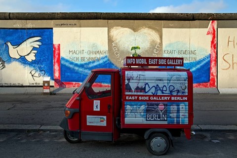 Info Mobil East Side Gallery in front of Peace Dove by Rosemarie Schinzler on a remnant of the