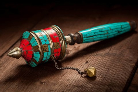 Tibetan buddhist Mani wheel or hand prayer wheel on wooden background
