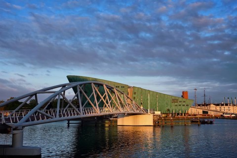 AMSTERDAM, NETHERLANDS, MAY 9, 2017: NEMO Science museum and Mr. J. van der Veldebrug bridge. It is